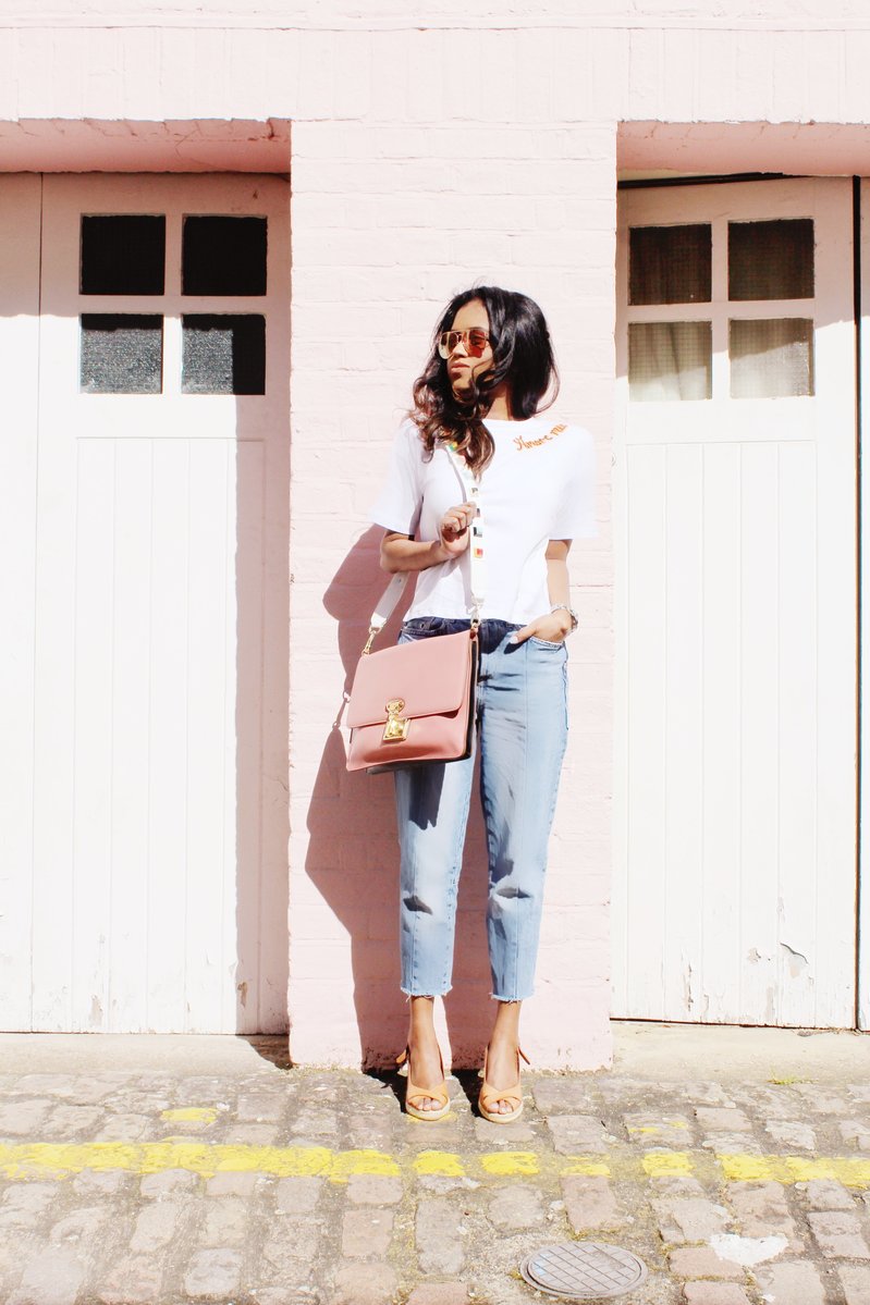 Sachini wearing a white t-shirt, blue jeans with a pink Dolce and Gabanna