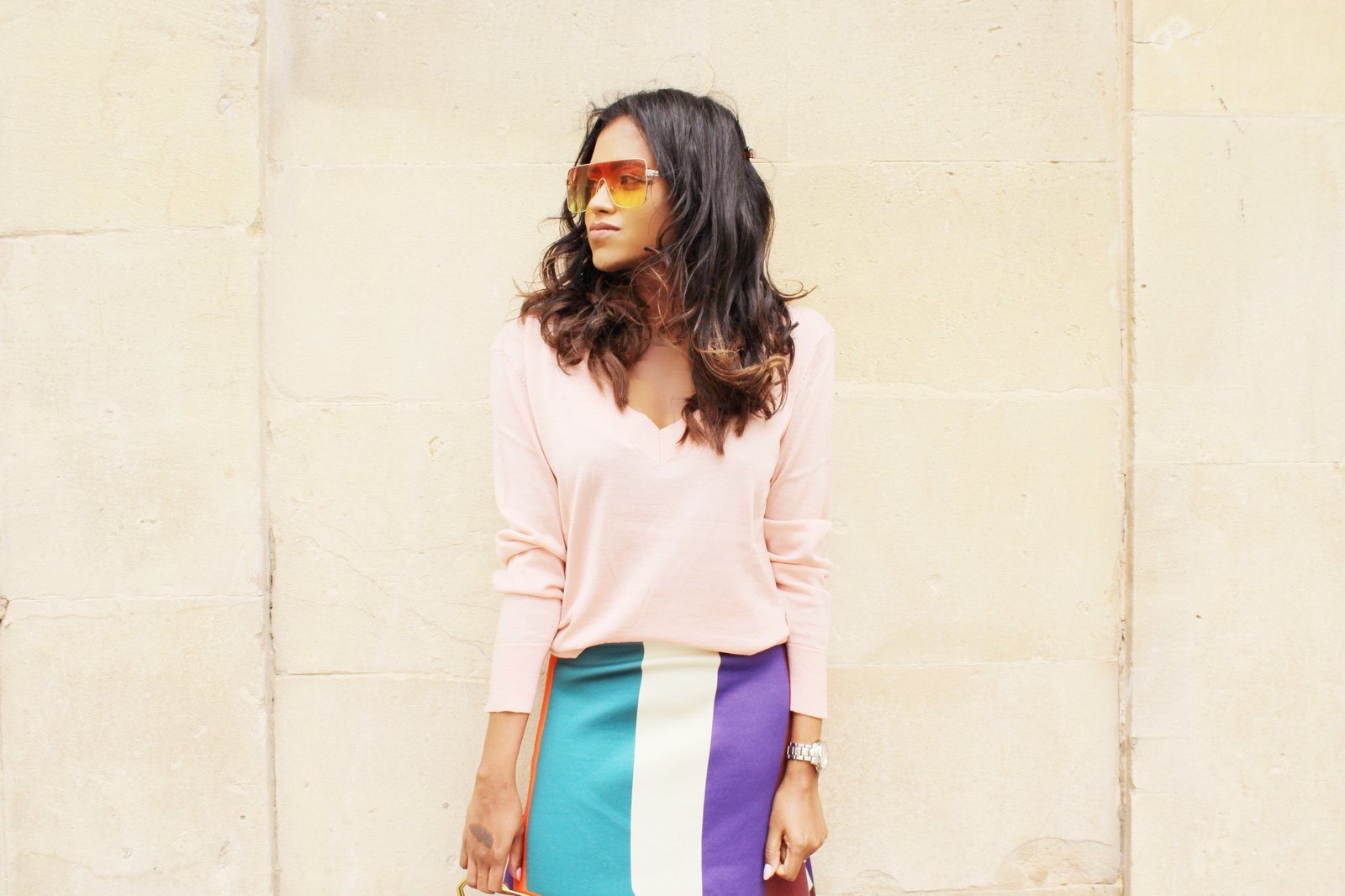 Sachini wearing sunglasses, a pink top and a colour blocked skirt