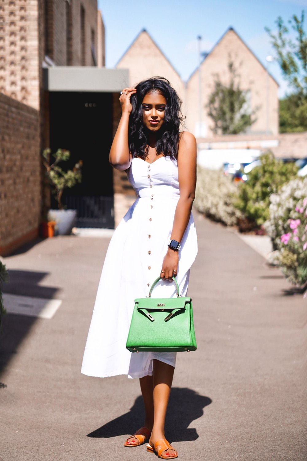 Sachini wearing a white dress holding green bag