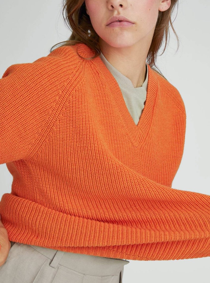 Model wearing orange knitwear
