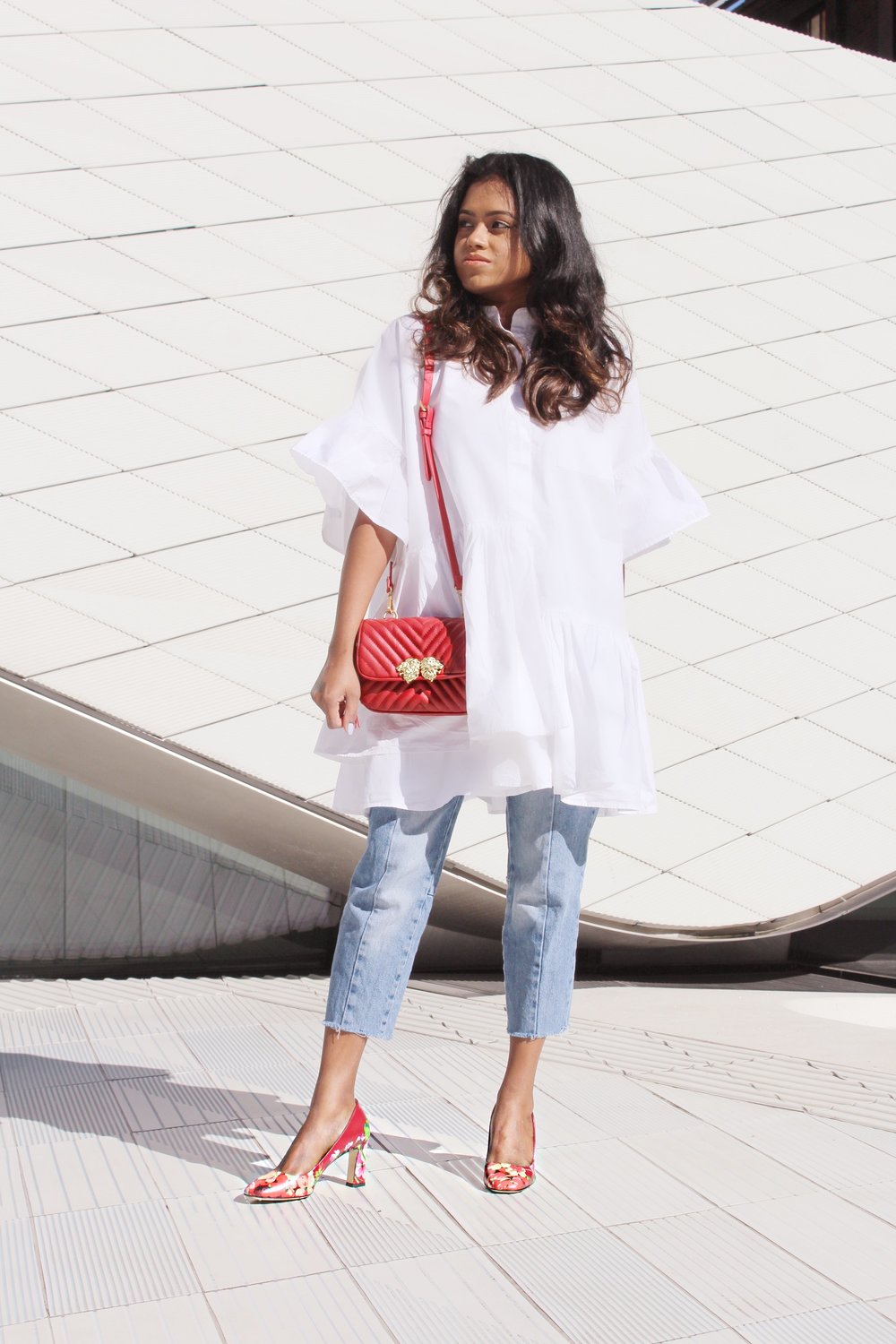 Sachini wearing a white dress, red Gucci shoes and Levi's jeans