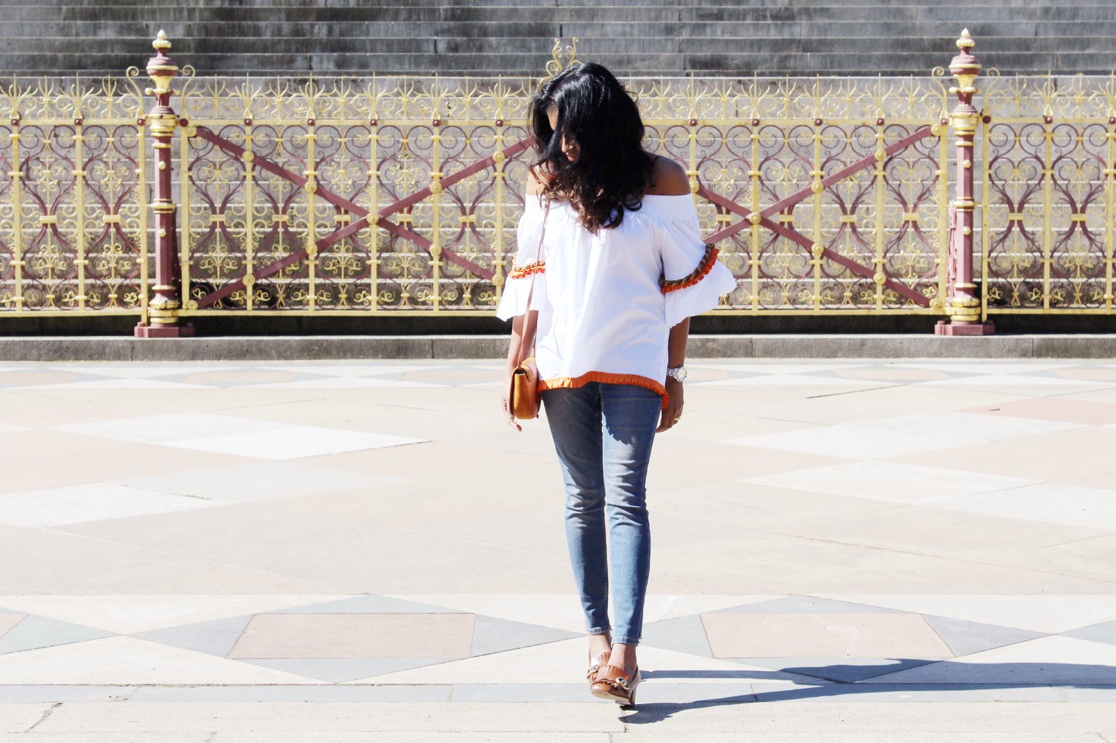 Sachini wearing a white top, blue jeans, brown Gucci shoes with a brown handbag