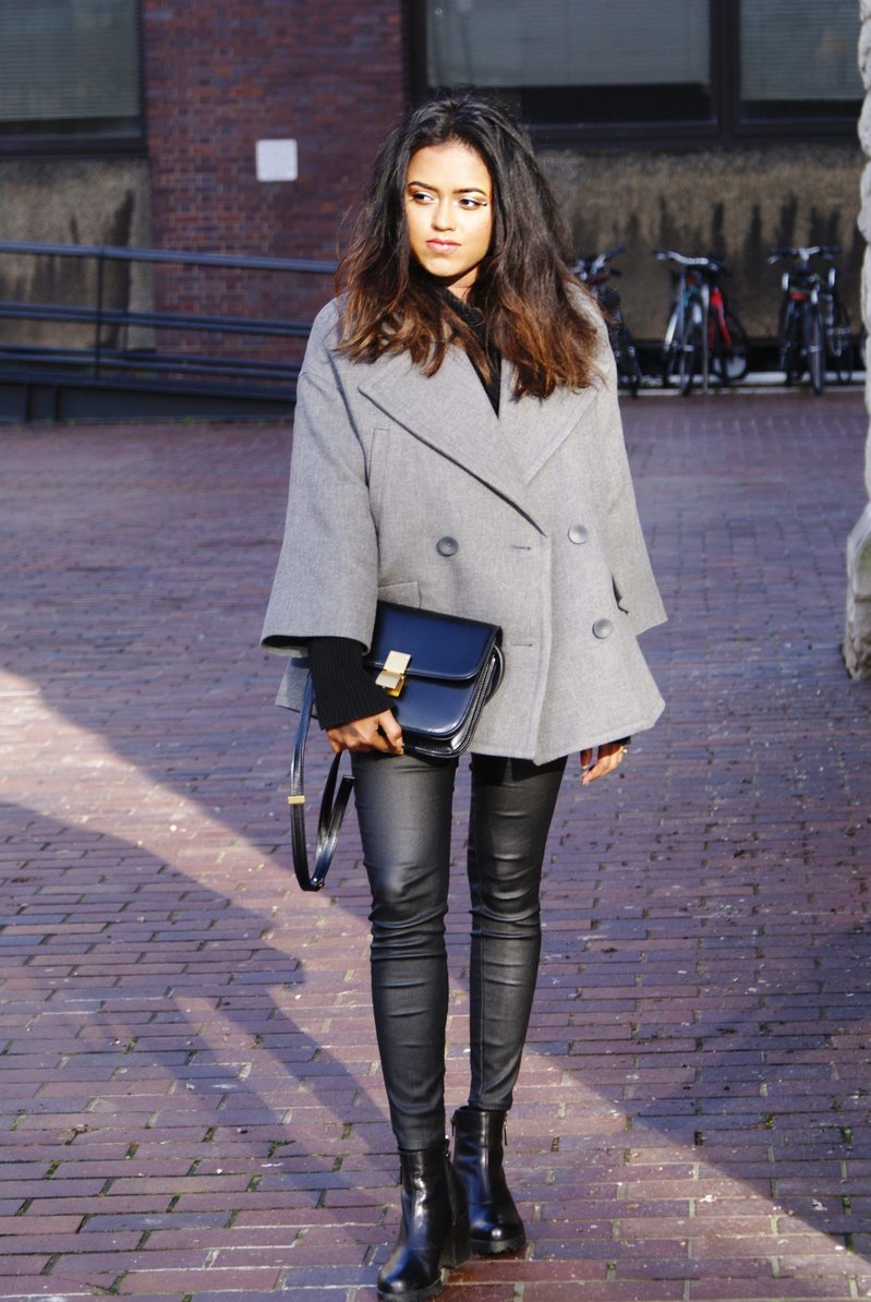 Sachini wearing a grey coat, black trousers with a black bag
