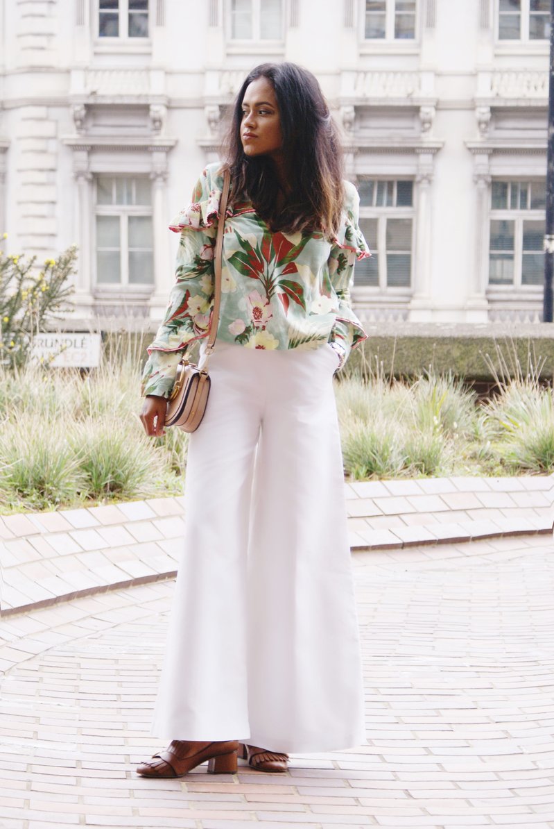 Sachini wearing a floral top and brown Gucci shoes holding a pink Chloé bag