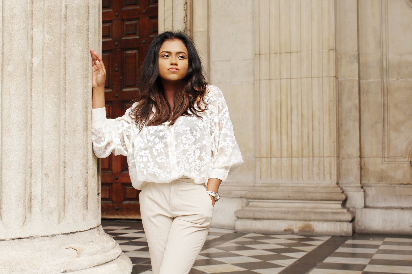 Close up of Sachini wearing a white top and beige trousers 