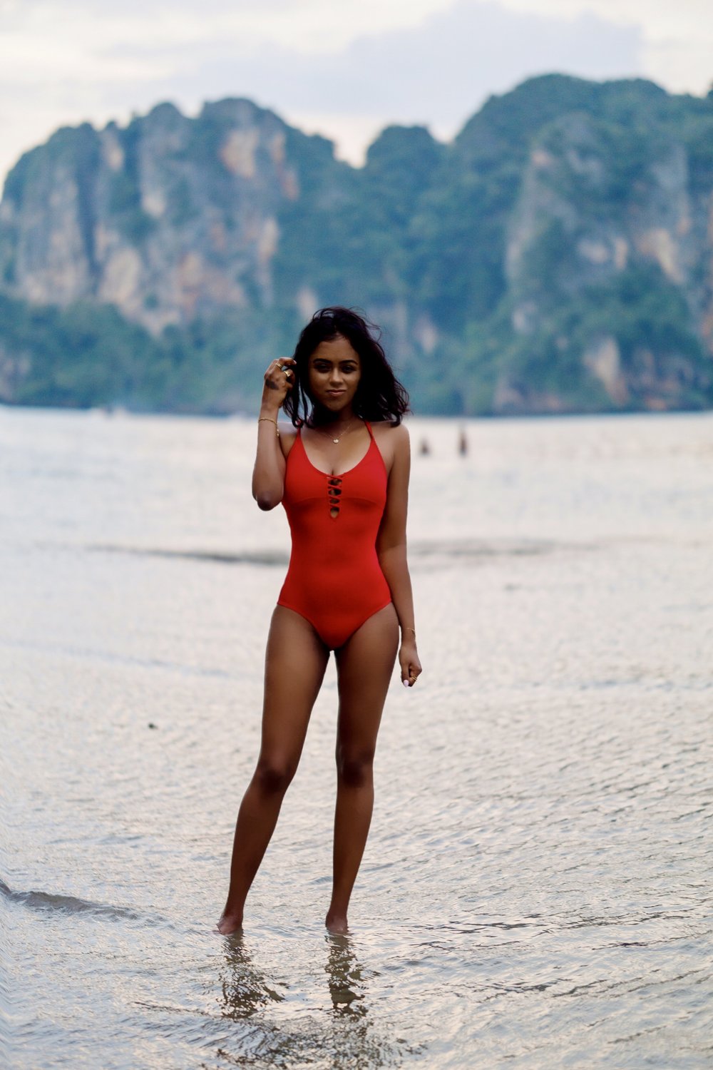 Sachini wearing a red swimsuit on a beach