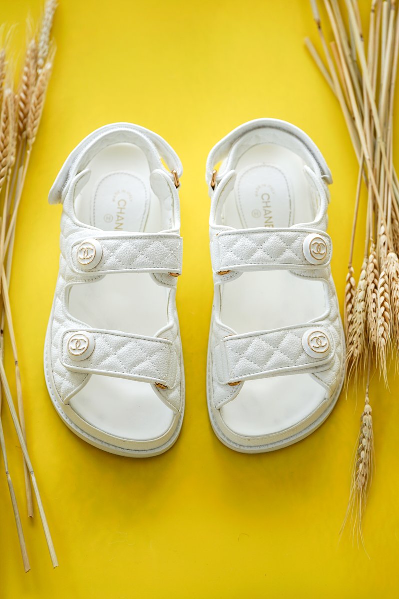White Chanel grandpa sandals on a yellow background
