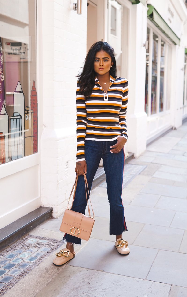 Sachini wearing a JW ANDERSON top holding a Drip pink bag