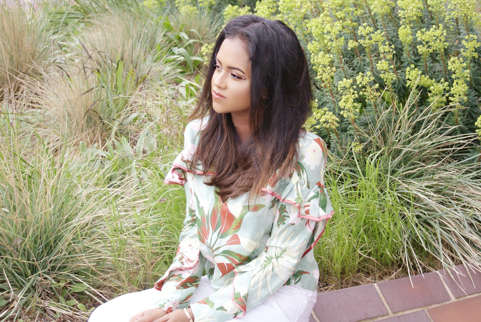 Close up of Sachini wearing a floral top in an urban garden