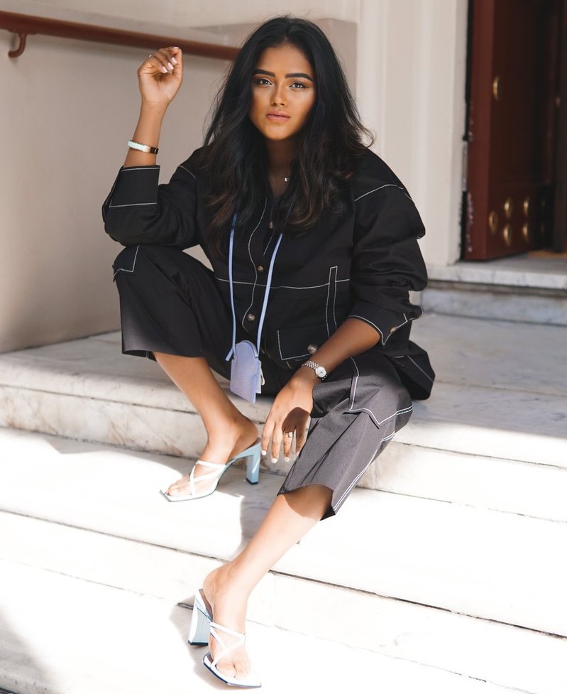 Sachini sitting down on stairs and wearing a black rejinapyo outfit