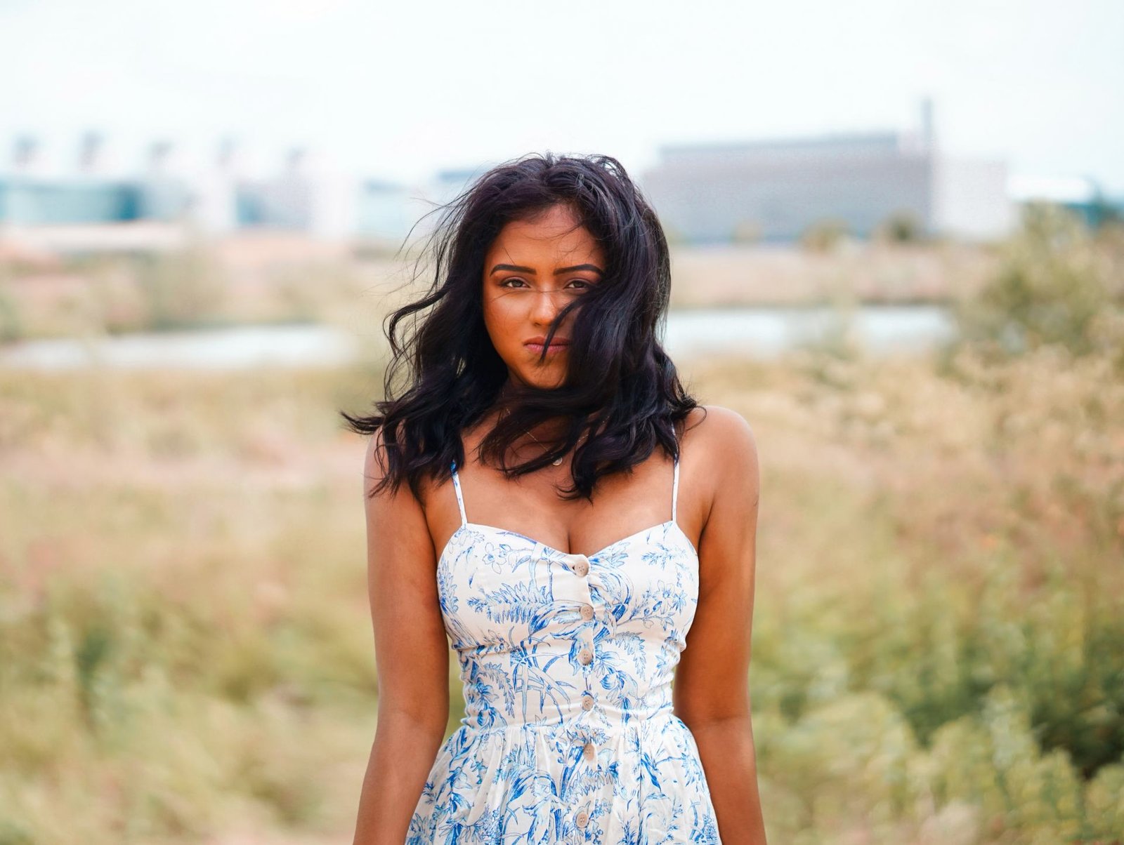 Close up of Sachini wearing a white and blue dress in a field 