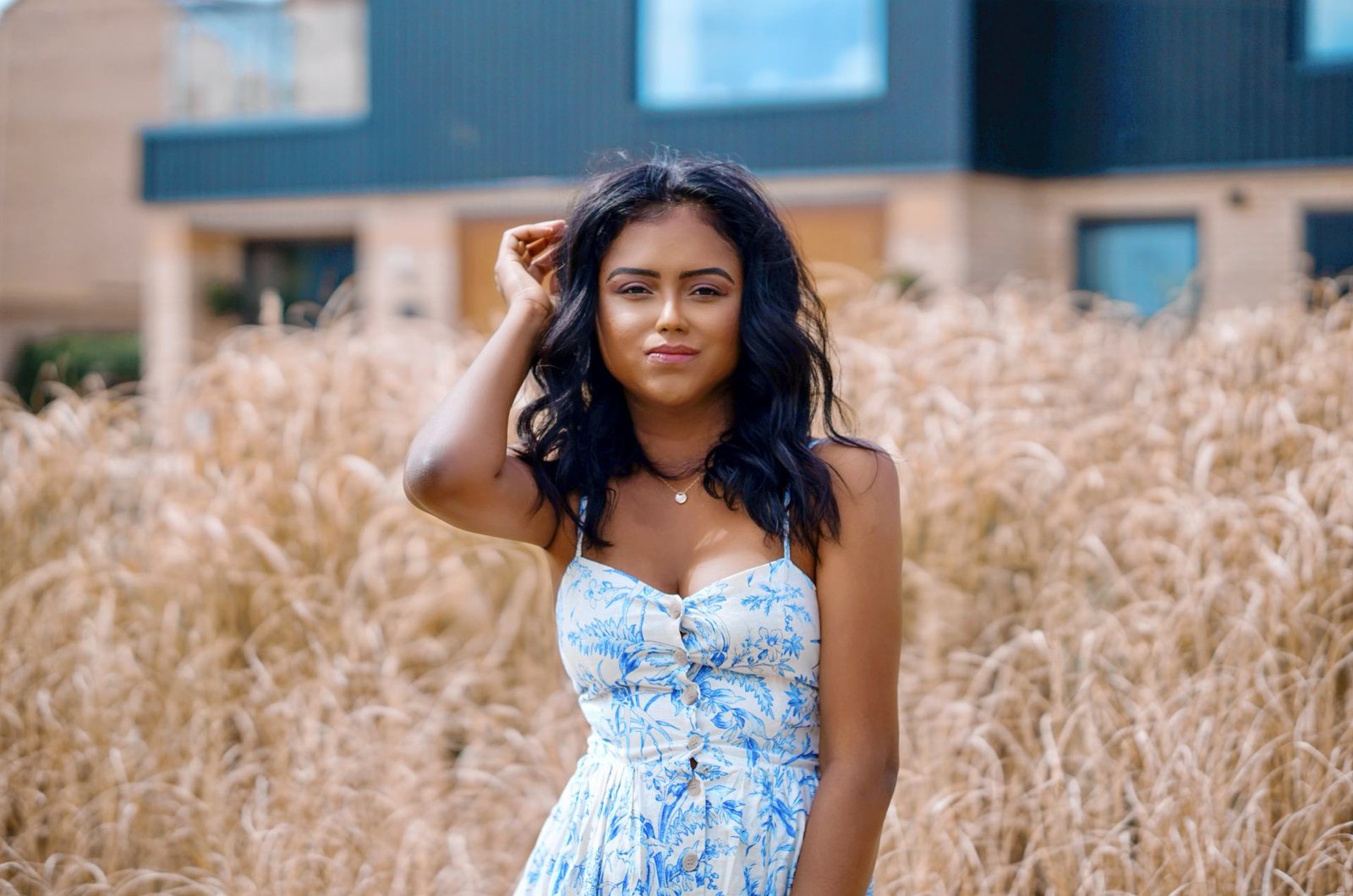 Close up of Sachini wearing a white and blue dress in a field 