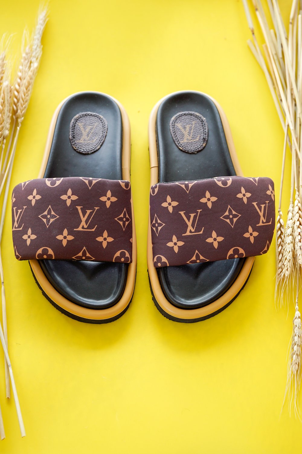Louis Vuitton slides on a yellow background