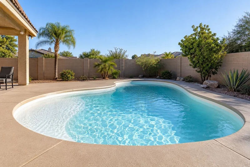 Pool with tan decking and a spa in warm sunset light