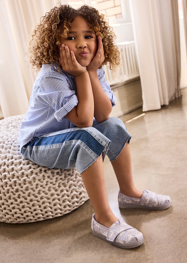 Model wearing Alpargata Classic Toddler Shoe in misty lilac iridescent unicorn shown.