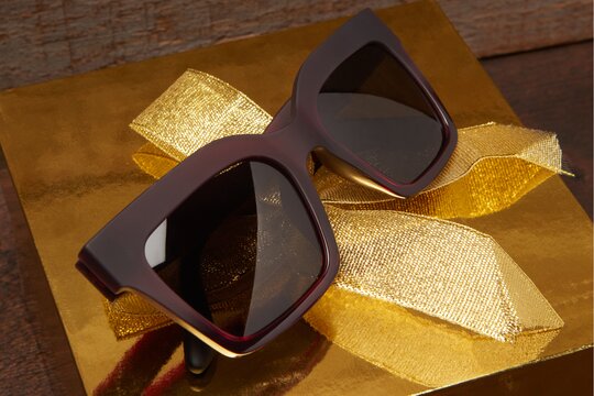 Sunglasses on gold ribbon.