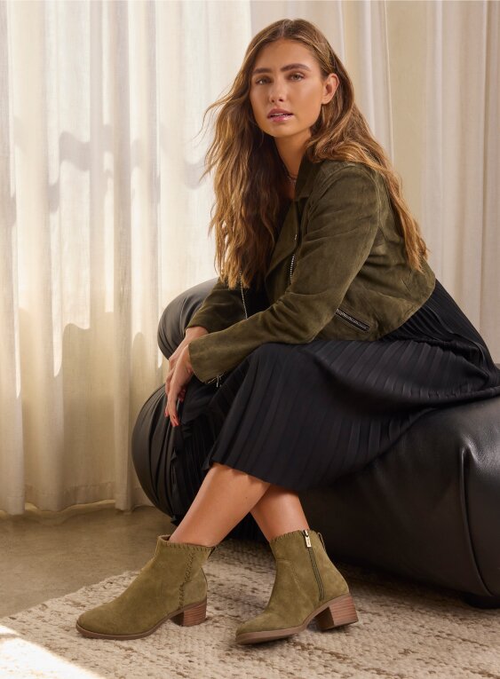 Model wearing women's Delilah Heeled Boot in water repellent military olive suede shown.