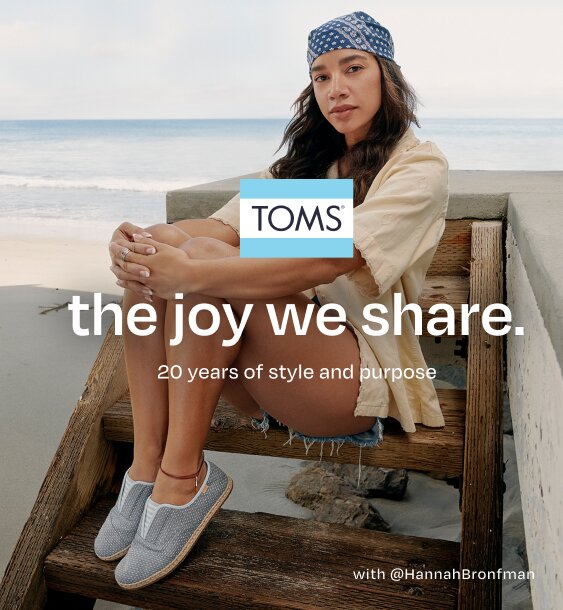 TOMS logo. the joy we share. 20 years of style and purpose. Caption: with @HannahBronfman. Hannah sitting. Beach background.