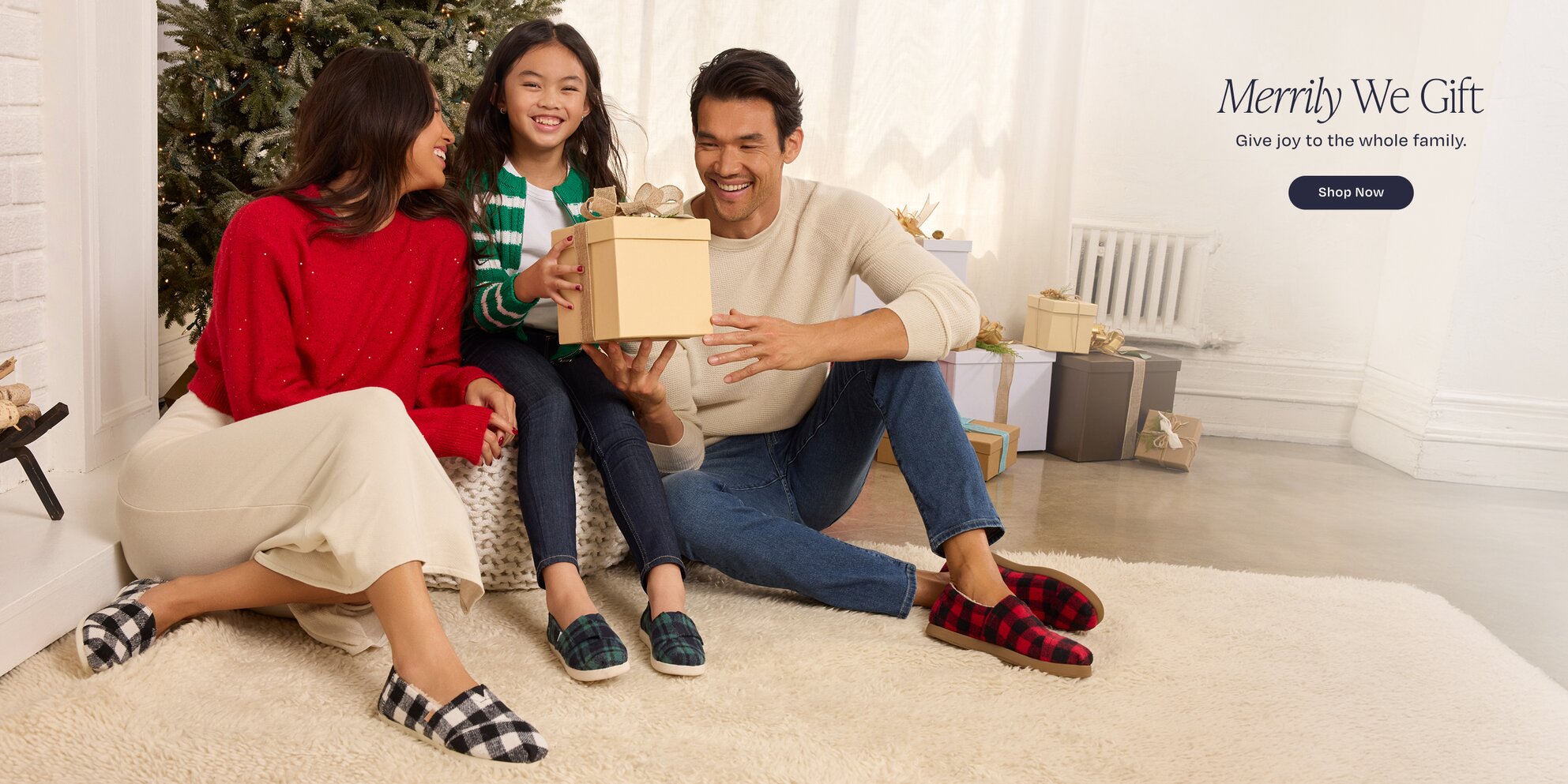 Merrily We Gift. Give joy to the whole family. Shop Now. A family wearing TOMS footwear shown.