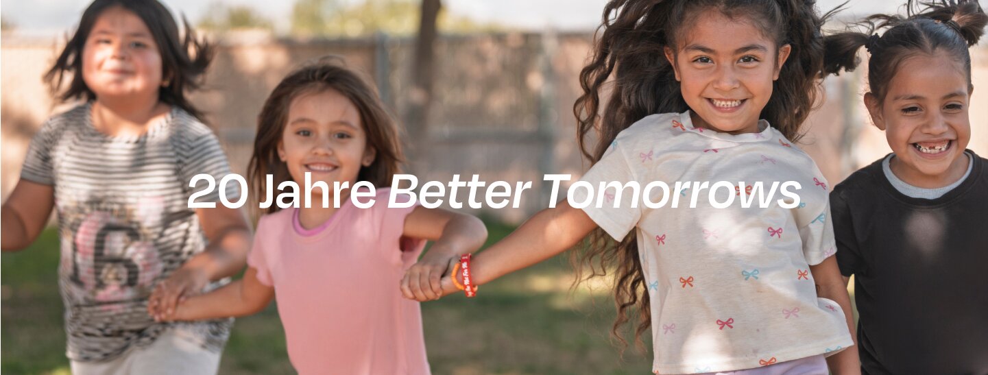 Children holding hands and smiling.