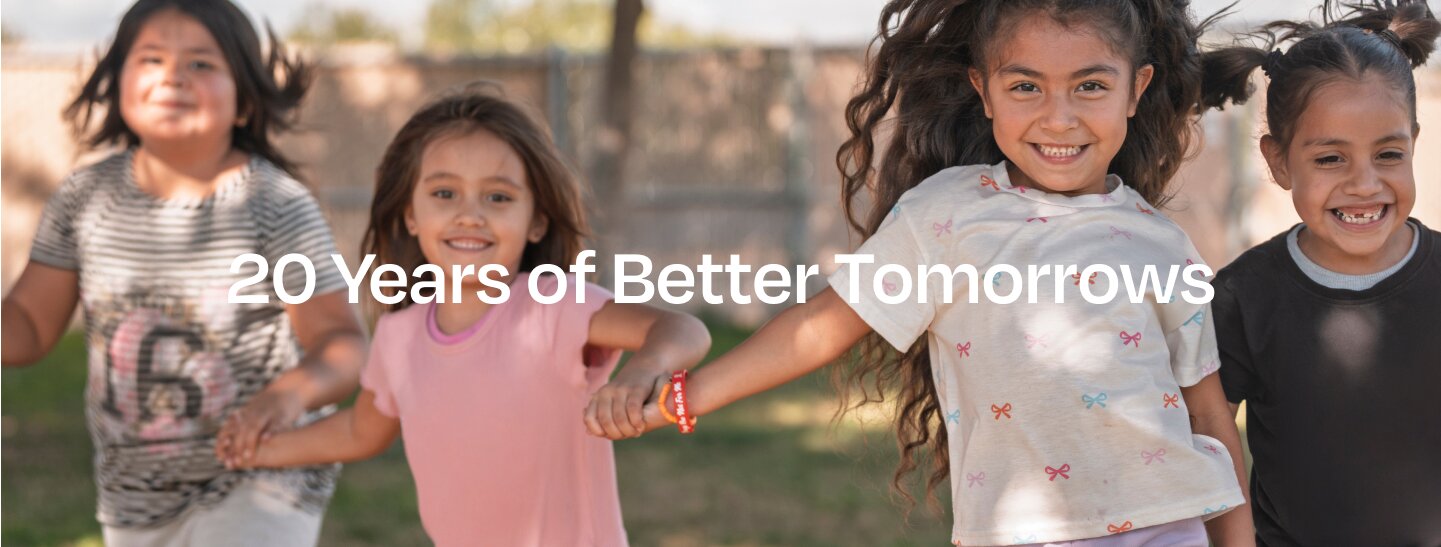 Children holding hands and smiling.