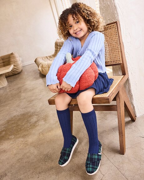 Model wearing Alpargata Classic Kids Shoe in navy plaid shown.