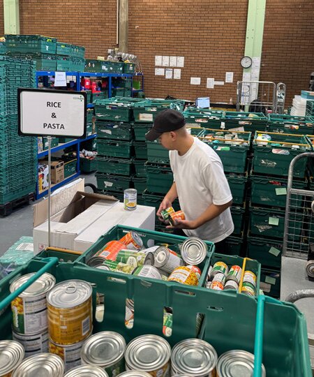 A TOMS employee sorting canned goods shown.