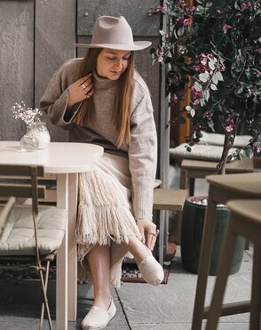 Content creator wearing Alpargata and sitting at dining table.