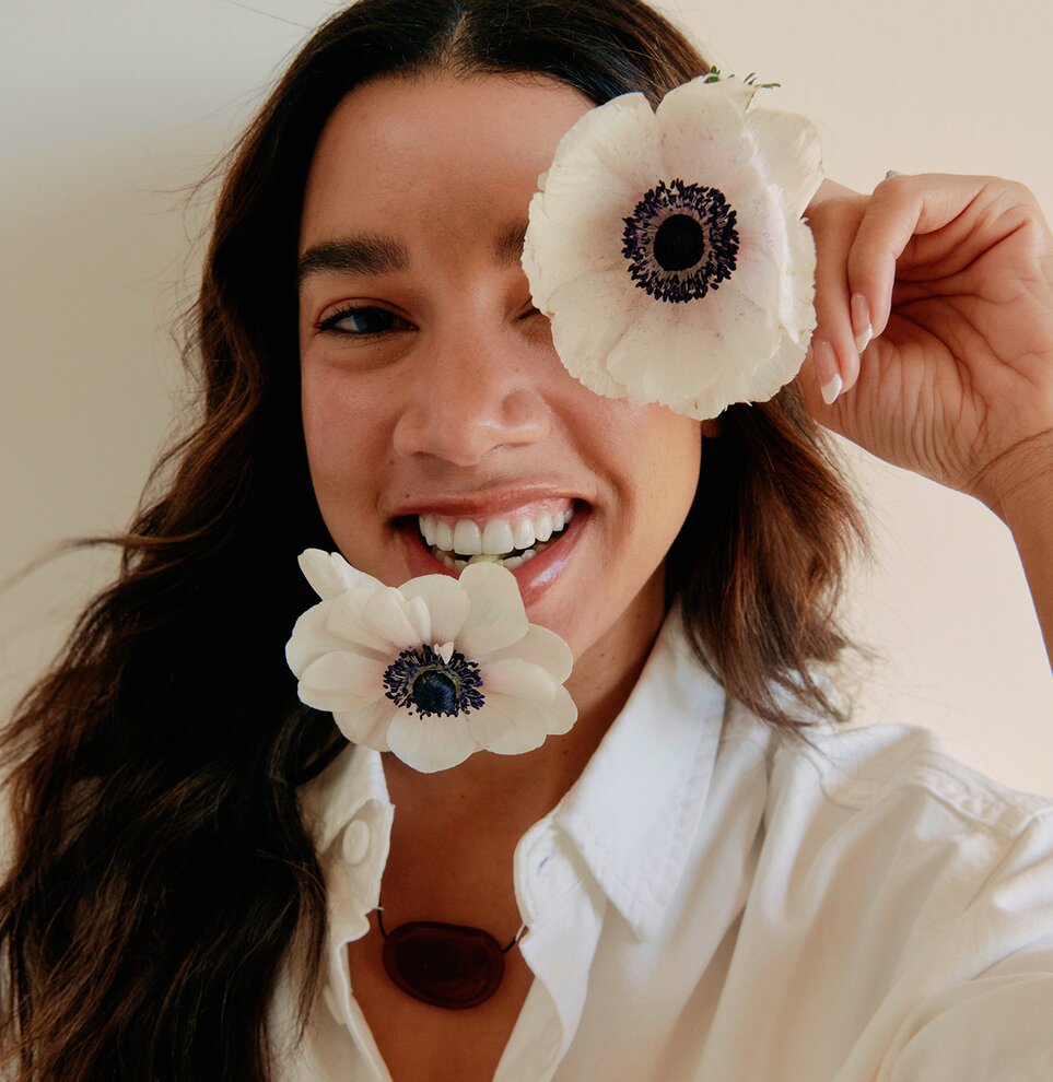 Hannah Bronfman smiling with flowers.