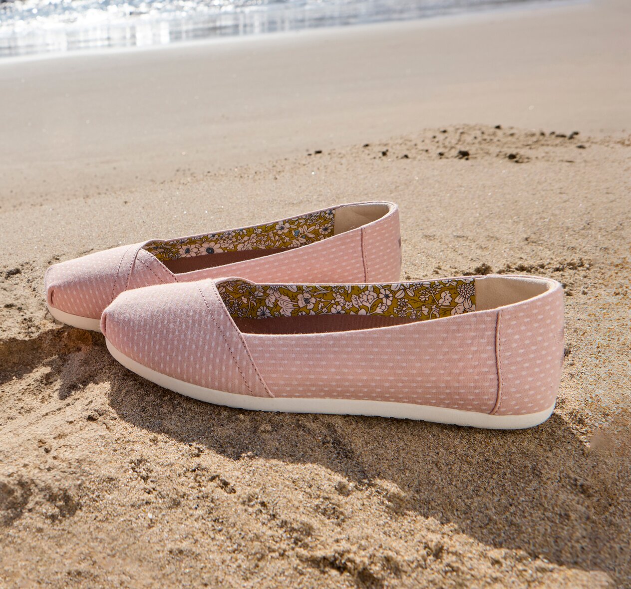 Beach background. Alpargata Ballet Flat in Bloom Chambray Dot on sand.