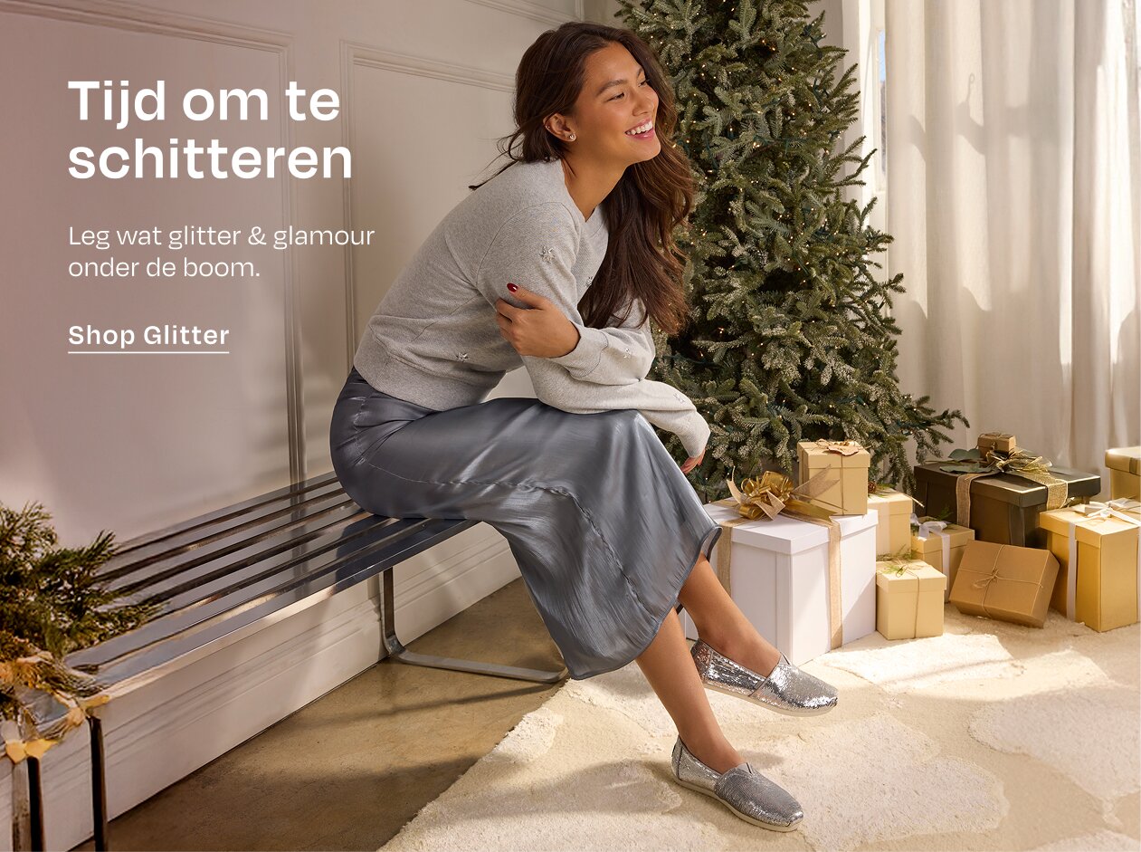 Tijd om te schitteren Leg wat glitter & glamour onder de boom. Shop Glitter Model in glinsterende Alpargata zittend op een bank.