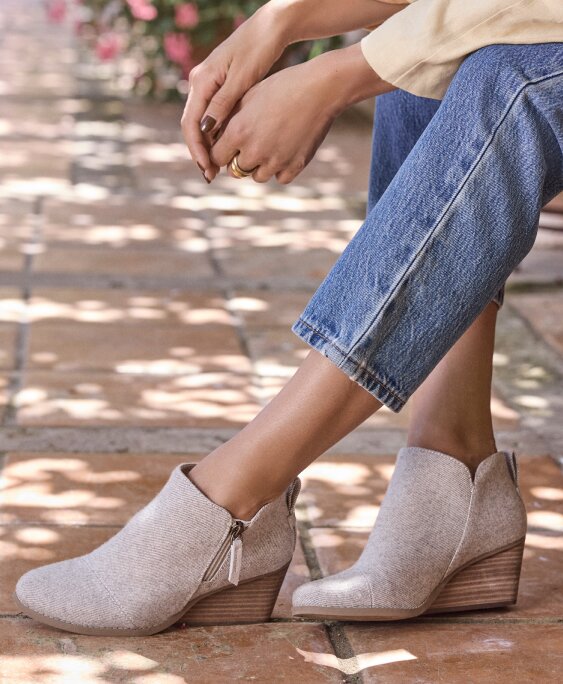 Model wearing Goldie Wedge Boot in natural glimmer shown.