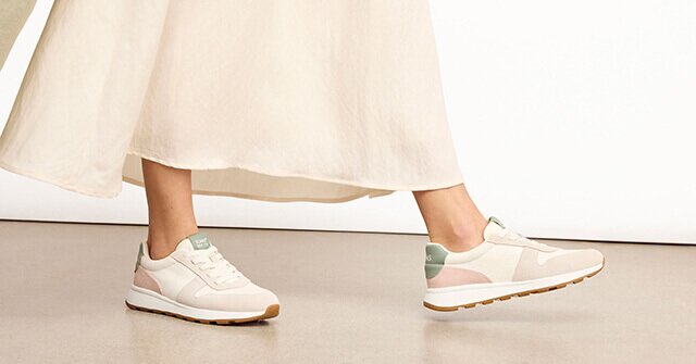 Model wearing the water-repellent TRVL LITE Retro Runner Sneaker in natural egret shown.