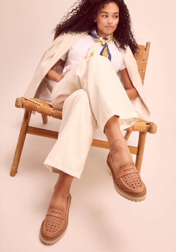 Model wearing Cara Loafer in brown sugar embossed perforated shown.