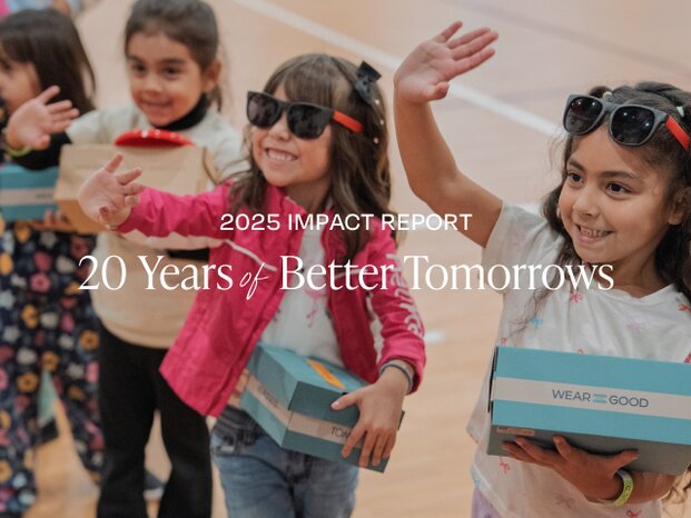 A group of smiling kids holding TOMS shoe boxes. 2025 IMPACT REPORT. 20 Years of Better Tomorrows.