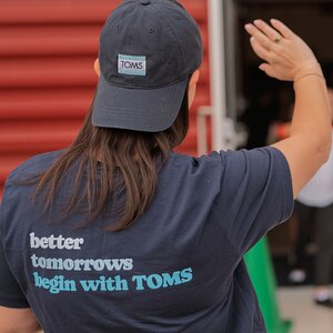 TOMS Team member wearing shirt "better tomorrows begin with TOMS".