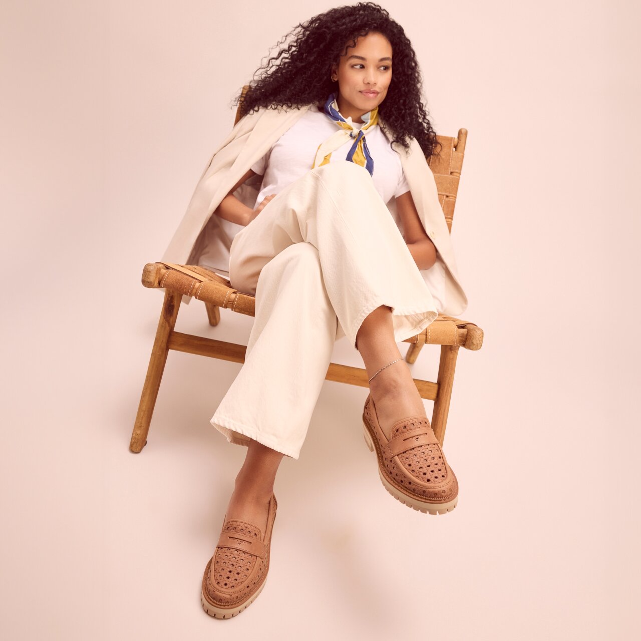 Model wearing Cara Loafer in brown sugar embossed perforated shown.