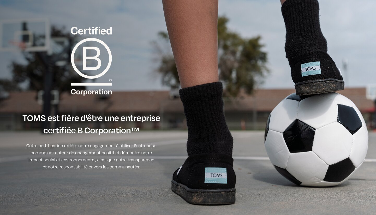 Bcorp logo. TOMS is proud to be a  Certified B Corporation™. This certification reflects our commitment to using business as a force for good and demonstrates our social and environmental impact, transparency and accountability. Child resting foot on soccer ball.