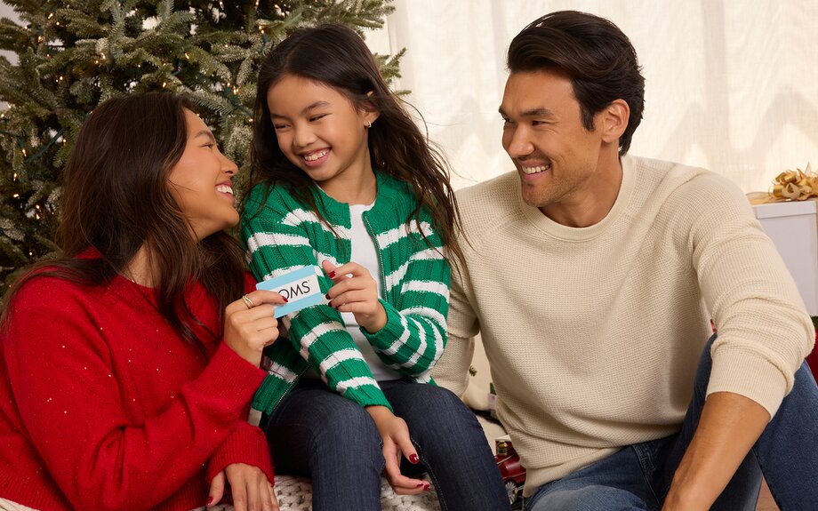 A family holding a TOMS gift card shown.