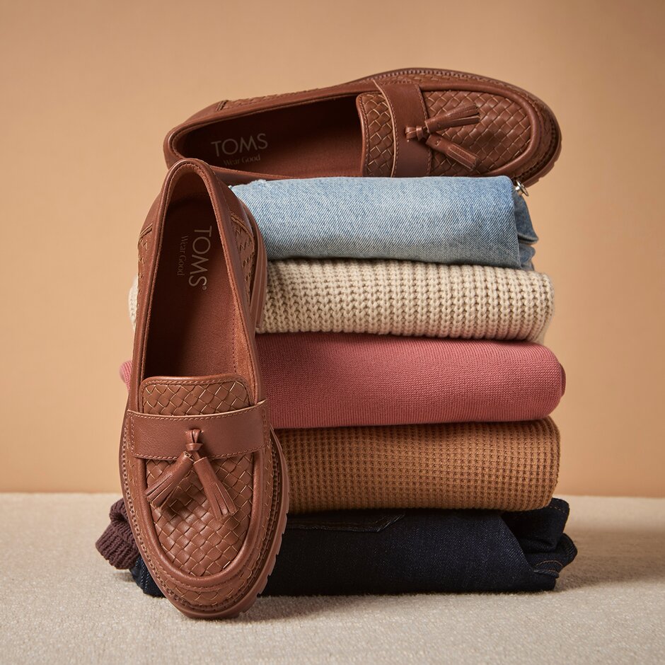 Cara Tassel Loafer shown with a stack of clothes.