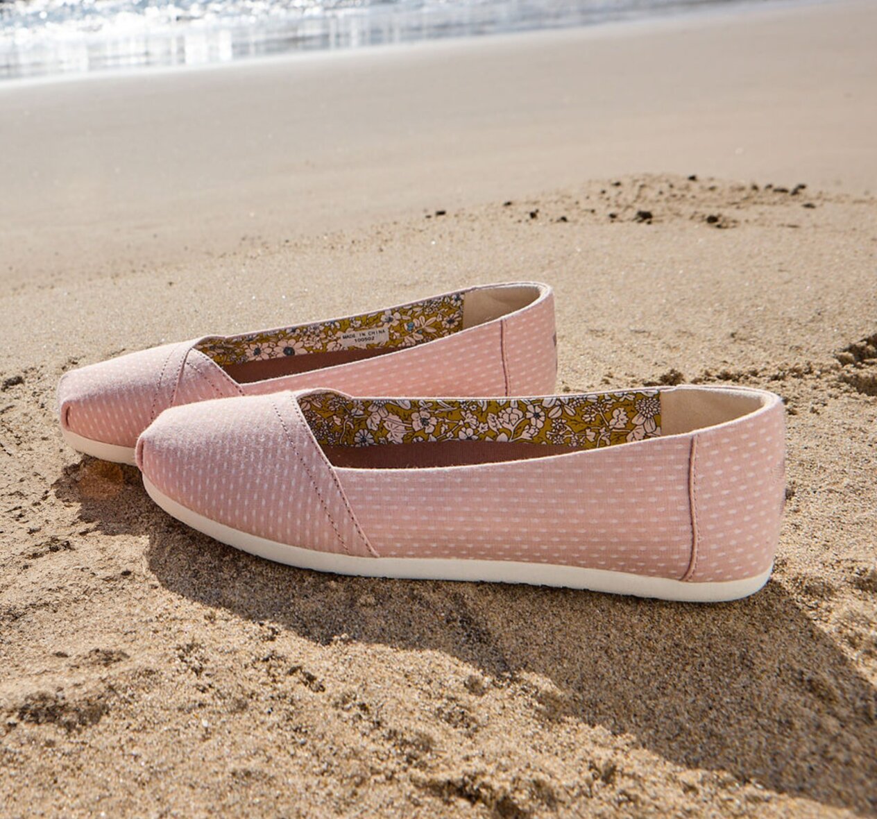 Beach background. Alpargata Ballet Flat in Bloom Chambray Dot on sand.