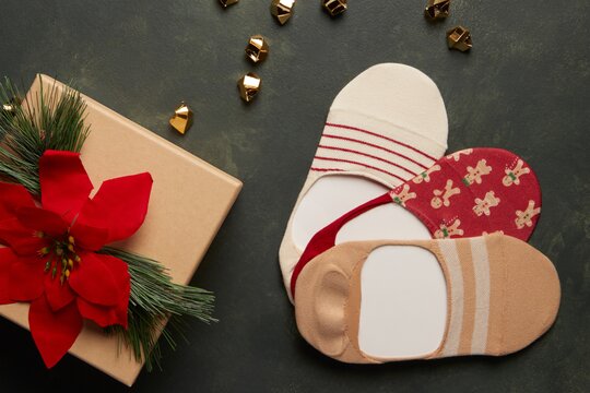 3 pack gingerbread print socks next to a poinsettia.