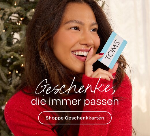Geschenke, die immer passen Shoppe Geschenkkarten Model, das eine TOMS-Geschenkkarte hält.