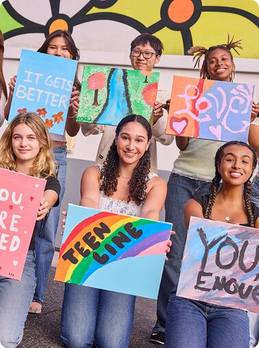 Teenagers holding paintings from Didi Hirsch Mental Health Services.