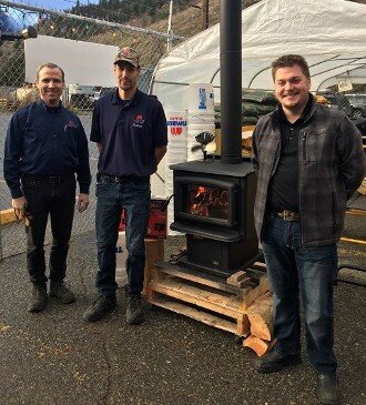 Workers standing by a wood stove