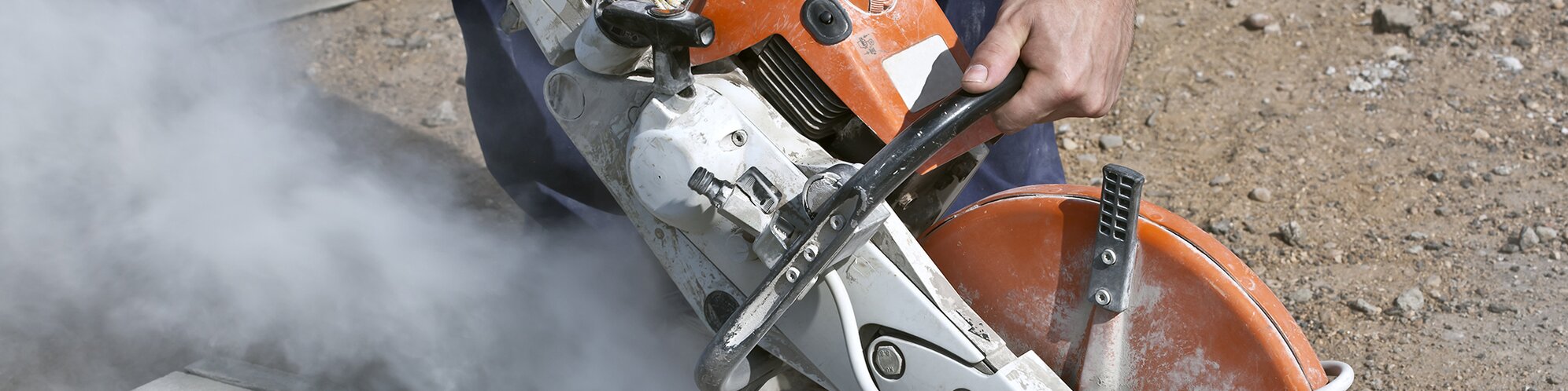 Worker using circular saw on concrete