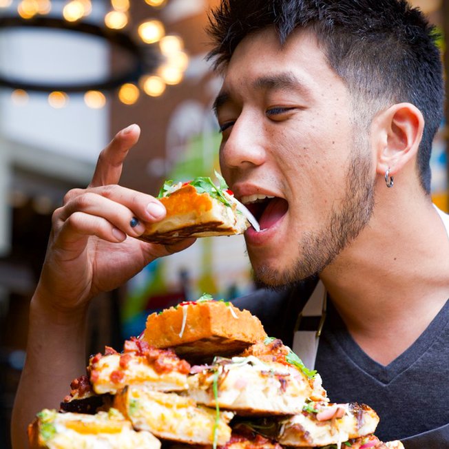 Chef Shota Nakajima taking a bite of Kobo pizza