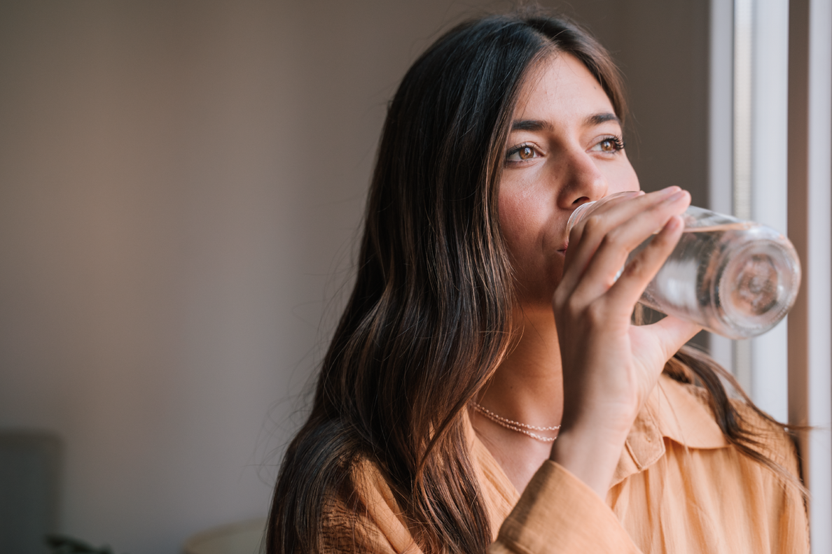 mujer tomando agua alcalina