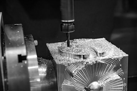 CNC machine using an end mill to cut away metal using various tool paths