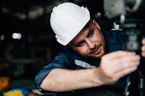 CNC operator machinist sets up machine with a drill bit or end mill